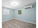 Bright bedroom with updated vinyl flooring, mini-split AC, and dual windows at 13316 Carol Dr, Hudson, FL 34667