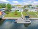 Waterfront home featuring a private dock and pontoon boat, set on a manicured lawn with lush landscaping at 13316 Carol Dr, Hudson, FL 34667