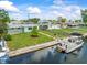 Waterfront home featuring a private dock and pontoon boat, with a tidy lawn and attractive landscaping at 13316 Carol Dr, Hudson, FL 34667