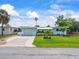 Single-story home with large lawn, landscaping, and a charming covered front porch area at 13316 Carol Dr, Hudson, FL 34667