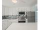 Bright kitchen with white cabinets, stainless steel appliances, and a breakfast bar at 13316 Carol Dr, Hudson, FL 34667