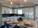 Bright kitchen features a center island, white cabinets, dark backsplash, and modern appliances at 1365 Snell Isle Ne Blvd # 6E, St Petersburg, FL 33704