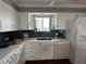 Well-lit kitchen showcasing white cabinetry, a stainless steel sink, and a dark backsplash at 1365 Snell Isle Ne Blvd # 6E, St Petersburg, FL 33704