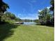 Lush backyard featuring serene lake view with a private wooden dock at 14935 Ogden Loop, Odessa, FL 33556