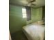 Small, green bedroom with a window, ceiling fan, and a bed at 14935 Ogden Loop, Odessa, FL 33556