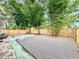 Large backyard featuring a full fence, gravel and scattered trees at 1554 Elmwood St, Clearwater, FL 33755