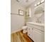 Bathroom features a white vanity, new lighting fixture, round mirror and tiled floors at 1554 Elmwood St, Clearwater, FL 33755