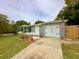 Beautiful home boasting mature landscaping, fresh exterior paint, an attached one-car garage and a long driveway at 1554 Elmwood St, Clearwater, FL 33755