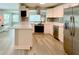 Stylish kitchen featuring stainless steel appliances, quartz countertops, white cabinets, and new flooring at 1554 Elmwood St, Clearwater, FL 33755