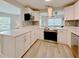 Bright modern kitchen with white cabinets, stainless steel appliances, and a convenient island for food prep at 1554 Elmwood St, Clearwater, FL 33755