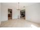 Bright dining room with tile flooring and a decorative chandelier, open to the kitchen and living areas at 15612 Farnsworth Ln, Tampa, FL 33624