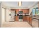 Well-equipped kitchen with stainless steel appliances, granite countertops, wooden cabinets, and a bright window at 15612 Farnsworth Ln, Tampa, FL 33624