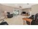 Spacious living room with tile flooring, comfortable seating, ceiling fan, and a sliding glass door leading to the outdoors at 15612 Farnsworth Ln, Tampa, FL 33624