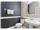 A half bathroom with dark blue accent wall, toilet, and pedestal sink at 1604 Acadia Harbor Pl, Brandon, FL 33511