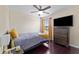 A simple bedroom with dark wood floors, ceiling fan, a TV and a window at 1604 Acadia Harbor Pl, Brandon, FL 33511