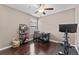 A simple bedroom with a desk, chair, ceiling fan, and a television on a workout machine at 1604 Acadia Harbor Pl, Brandon, FL 33511
