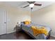 A simple bedroom with dark wood floors, ceiling fan, and a nightstand at 1604 Acadia Harbor Pl, Brandon, FL 33511