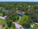 Sprawling property with a stately home, surrounded by lush greenery and mature trees, enclosed by a pink property line at 1681 Long Bow Ln, Clearwater, FL 33764
