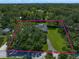 Aerial view showcasing the home and vast acreage surrounded by dense mature trees at 1681 Long Bow Ln, Clearwater, FL 33764