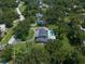 Bird's eye view captures the home's curb appeal, swimming pool, circular driveway, and mature trees at 1681 Long Bow Ln, Clearwater, FL 33764