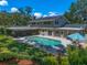 A beautifully landscaped backyard features a pool, screened patio, and lush greenery, creating an outdoor oasis at 1681 Long Bow Ln, Clearwater, FL 33764