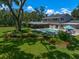 Inviting backyard with a pool, patio, lush landscaping, and a screened-in porch for outdoor enjoyment at 1681 Long Bow Ln, Clearwater, FL 33764