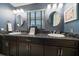 Bathroom with dual sinks, dark wood cabinets, and sleek fixtures under matching light fixtures at 1681 Long Bow Ln, Clearwater, FL 33764