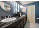 Bathroom boasts dual sinks, dark wood cabinets, and sleek fixtures under matching light fixtures at 1681 Long Bow Ln, Clearwater, FL 33764