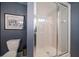 Bathroom features a glass-enclosed shower stall and matching blue wallpaper and accents at 1681 Long Bow Ln, Clearwater, FL 33764