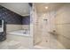 Bathroom with a soaking tub and glass shower area against blue floral wallpaper at 1681 Long Bow Ln, Clearwater, FL 33764