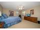 Cozy bedroom featuring a ceiling fan, Buccaneers memorabilia, and a TV on a wooden dresser at 1681 Long Bow Ln, Clearwater, FL 33764