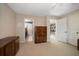 Spacious bedroom with an open doorway to a bathroom and staircase, with a large dresser for storage at 1681 Long Bow Ln, Clearwater, FL 33764