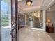 Bright foyer featuring marble floors, a grand staircase with a safety gate, and an elegant chandelier at 1681 Long Bow Ln, Clearwater, FL 33764