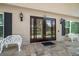Elegant entryway with decorative glass doors, stylish sconces, and quaint benches on a patterned stone porch at 1681 Long Bow Ln, Clearwater, FL 33764
