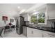Eat-in kitchen featuring stainless steel appliances, black countertops, and a window overlooking the backyard at 1681 Long Bow Ln, Clearwater, FL 33764
