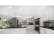 Kitchen with white cabinetry, stainless steel appliances, and a breakfast bar with black countertops at 1681 Long Bow Ln, Clearwater, FL 33764