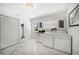Large laundry room featuring white cabinetry, washer and dryer, and white marble tile flooring at 1681 Long Bow Ln, Clearwater, FL 33764