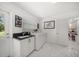 Bright laundry room with white cabinetry, black countertops, marble tile floors, and backyard access at 1681 Long Bow Ln, Clearwater, FL 33764