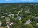Overhead view of the neighborhood with homes scattered throughout a lush landscape full of mature trees at 1681 Long Bow Ln, Clearwater, FL 33764