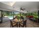Inviting screened patio with ceiling fans, stylish furniture, and view of the pool and lush backyard at 1681 Long Bow Ln, Clearwater, FL 33764