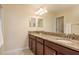 Bathroom with double sinks, granite countertop, wooden cabinets, mirror and tiled floor at 19309 Prairie Tree Pl, Tampa, FL 33647