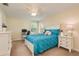 Bright bedroom with neutral walls, carpet, a teal comforter with decorative pillows, and white furniture at 19309 Prairie Tree Pl, Tampa, FL 33647