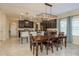 Dining room with dark wood table and chairs, and a view into the adjacent kitchen at 19309 Prairie Tree Pl, Tampa, FL 33647