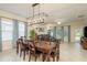 Dining area with a wooden table, view of living room, and bright natural light from large windows at 19309 Prairie Tree Pl, Tampa, FL 33647