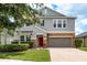 Charming two-story home with stone accents, a red door, and a well-manicured front yard at 19309 Prairie Tree Pl, Tampa, FL 33647