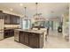 Spacious kitchen with dark cabinetry, granite countertops, and a large island with pendant lighting at 19309 Prairie Tree Pl, Tampa, FL 33647