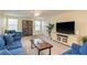Comfortable living room featuring neutral walls, plush carpet, and cozy denim furniture with flatscreen TV at 19309 Prairie Tree Pl, Tampa, FL 33647
