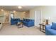 Bright living room featuring neutral walls, plush carpet, and comfortable denim-colored sofas with decorative pillows at 19309 Prairie Tree Pl, Tampa, FL 33647