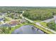 Beautiful overhead view shows a suburban home with a screened pool and pond, lush landscaping and trees at 2202 Hickory Ridge Dr, Valrico, FL 33596