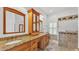 Bathroom with double sinks, granite counters, shutters and tiled shower at 2202 Hickory Ridge Dr, Valrico, FL 33596